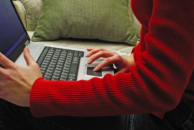 woman in red using laptop